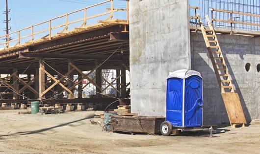 a row of modern portable toilets at a busy construction site, designed for easy use and maintenance